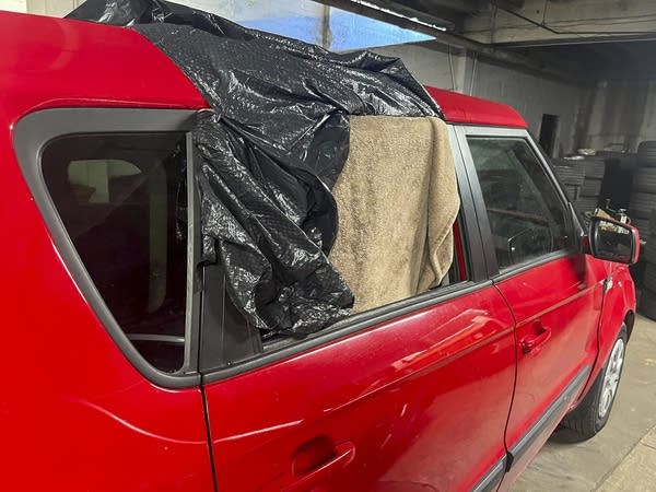 Vehicle with broken window in repair shop.