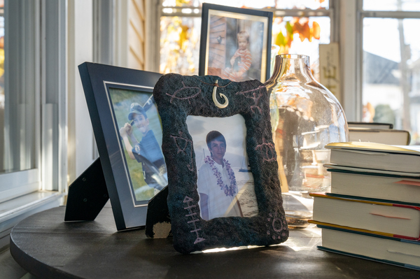 Framed photographs of McDonough's sons sit on a table.