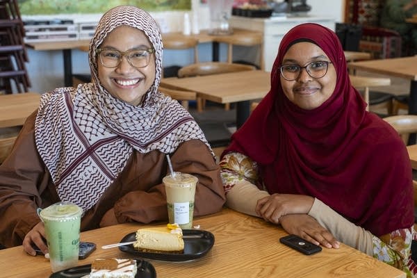 two women enjoy coffees and cakes