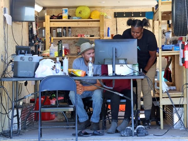 people sit at a table and look at a computer