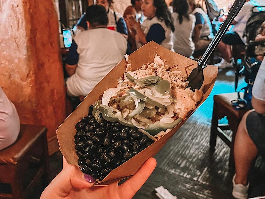 hand holding a burrito bowl from pecos bills at magic kingdom in disney world