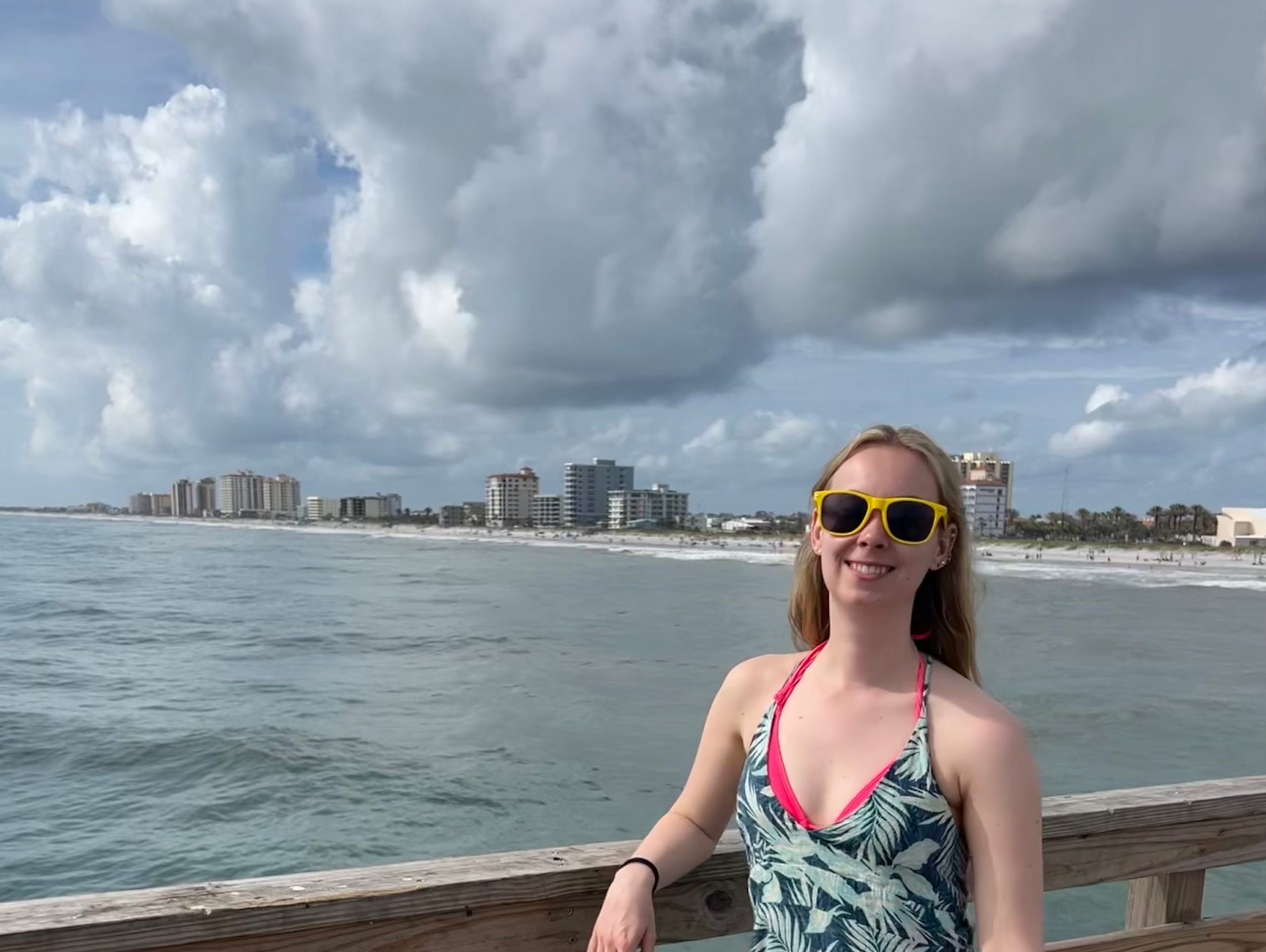 molly posing on a pier next to the water at jacksonville beach florida