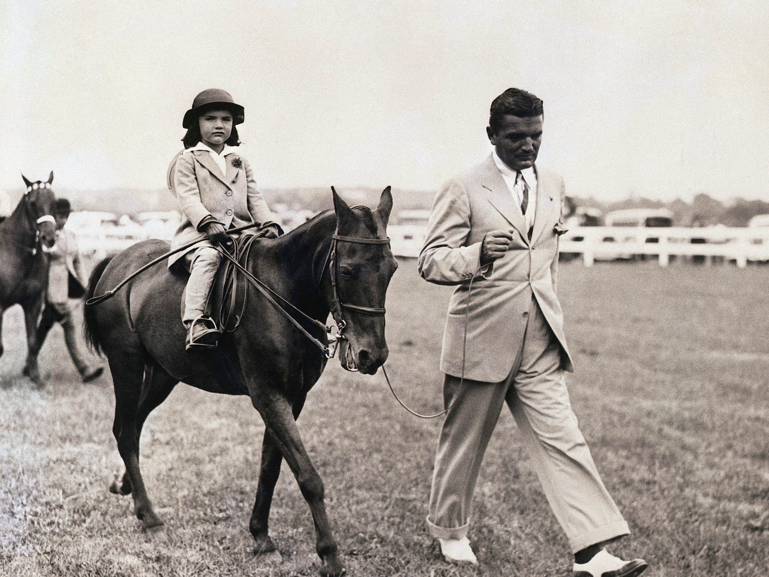 Jacqueline Bouvier rides horseback as her dad, John, walks at her side in East Hampton.