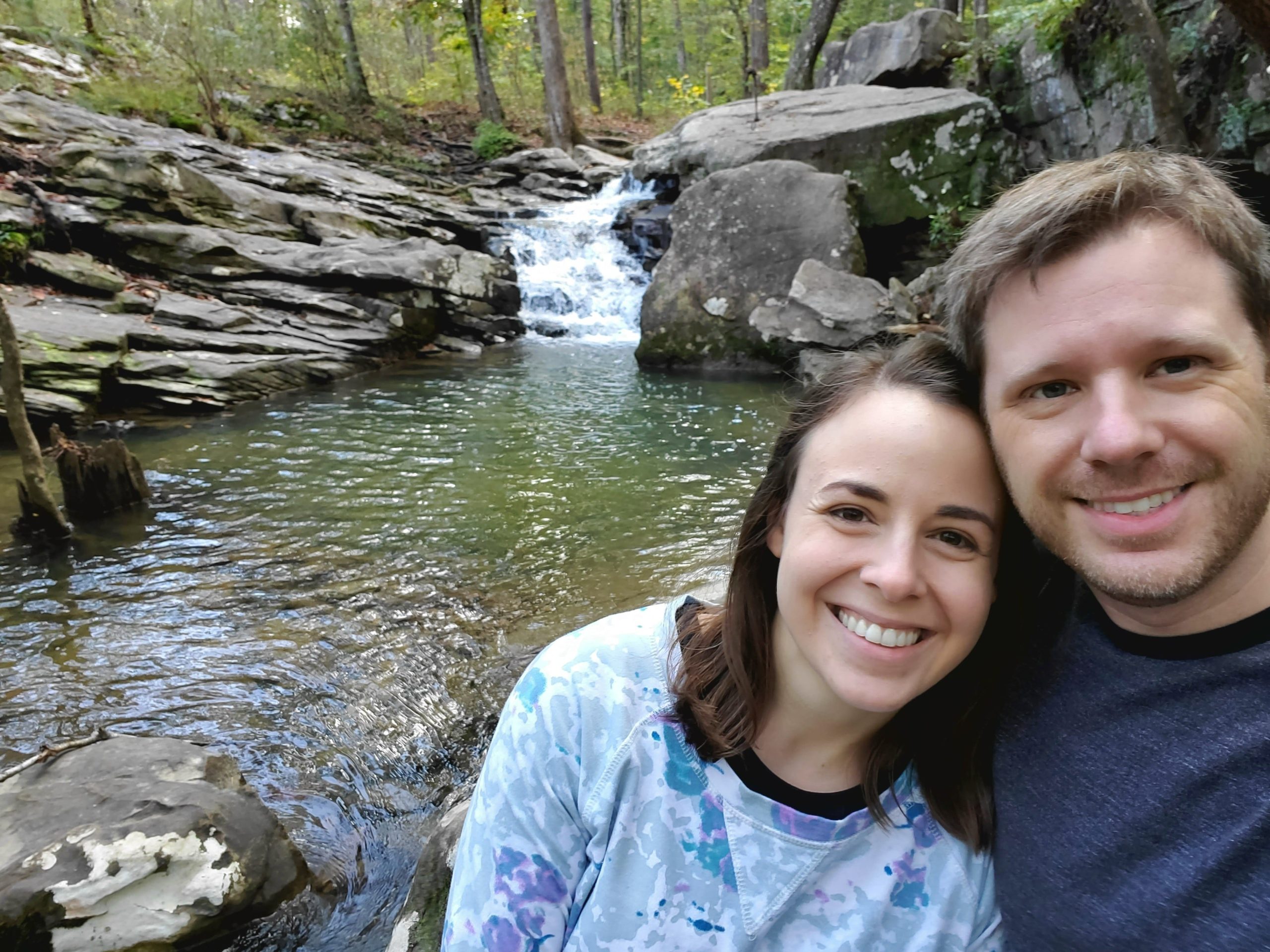 Katie Matthews and her husband standing in front of a riverbed.