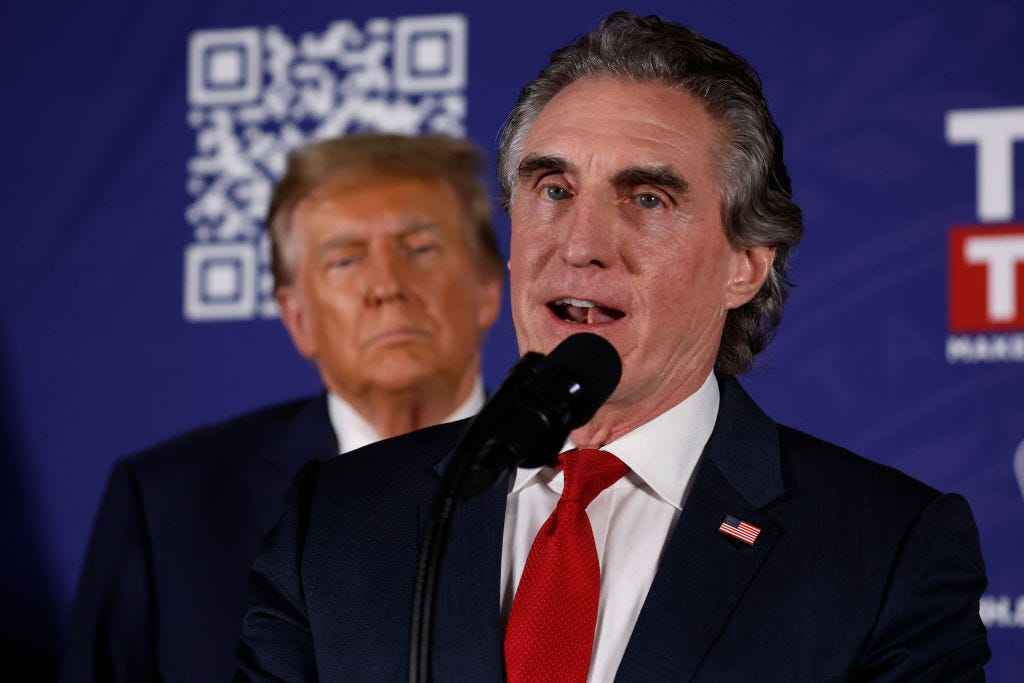 Donald Trump looks on as Doug Burgum endorses him