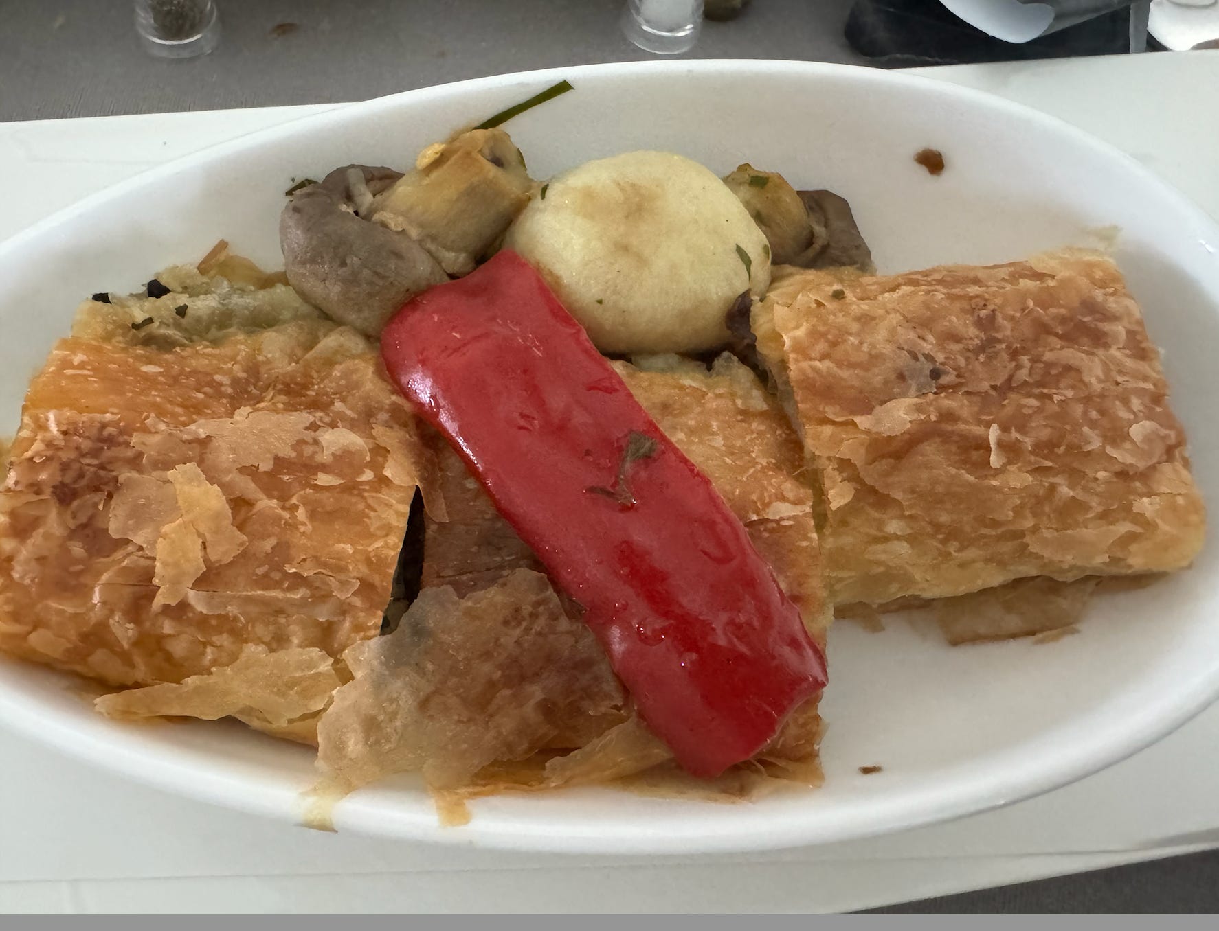 Flaky pastry on plate on airlane tray table 