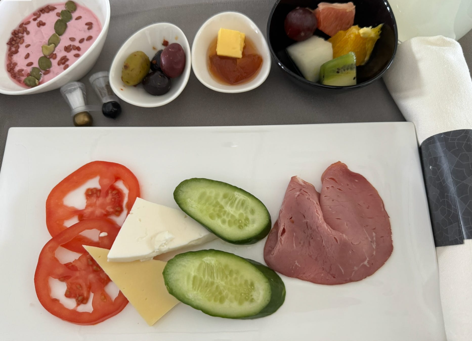 Cucumber, tomato, cheese on plate on airpla