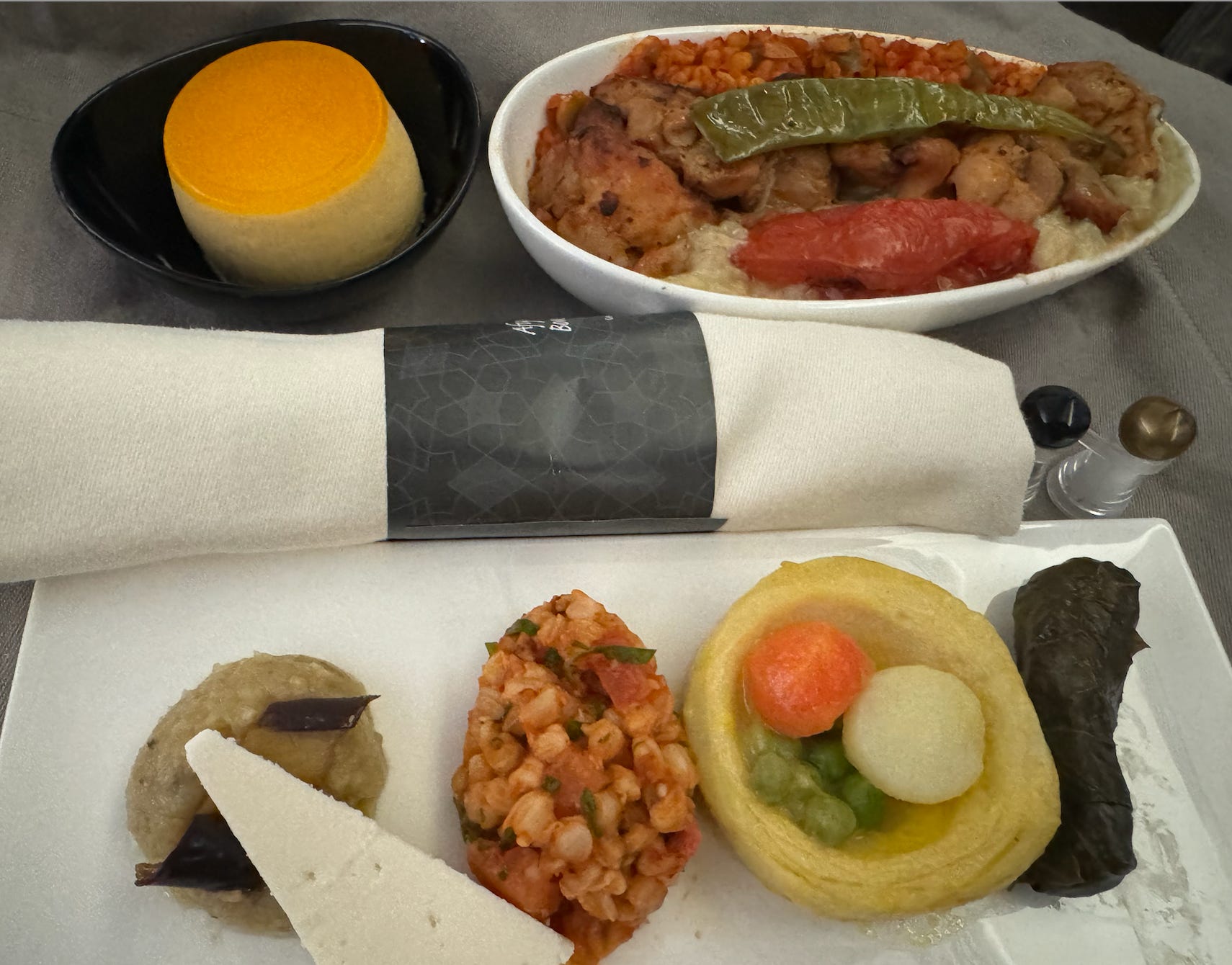 Selection of airline food and rolled napkin on tray table 