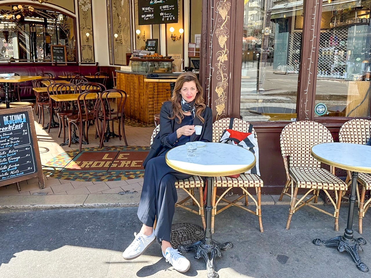 Author Kasia Dietz sitting drinking coffee in Paris