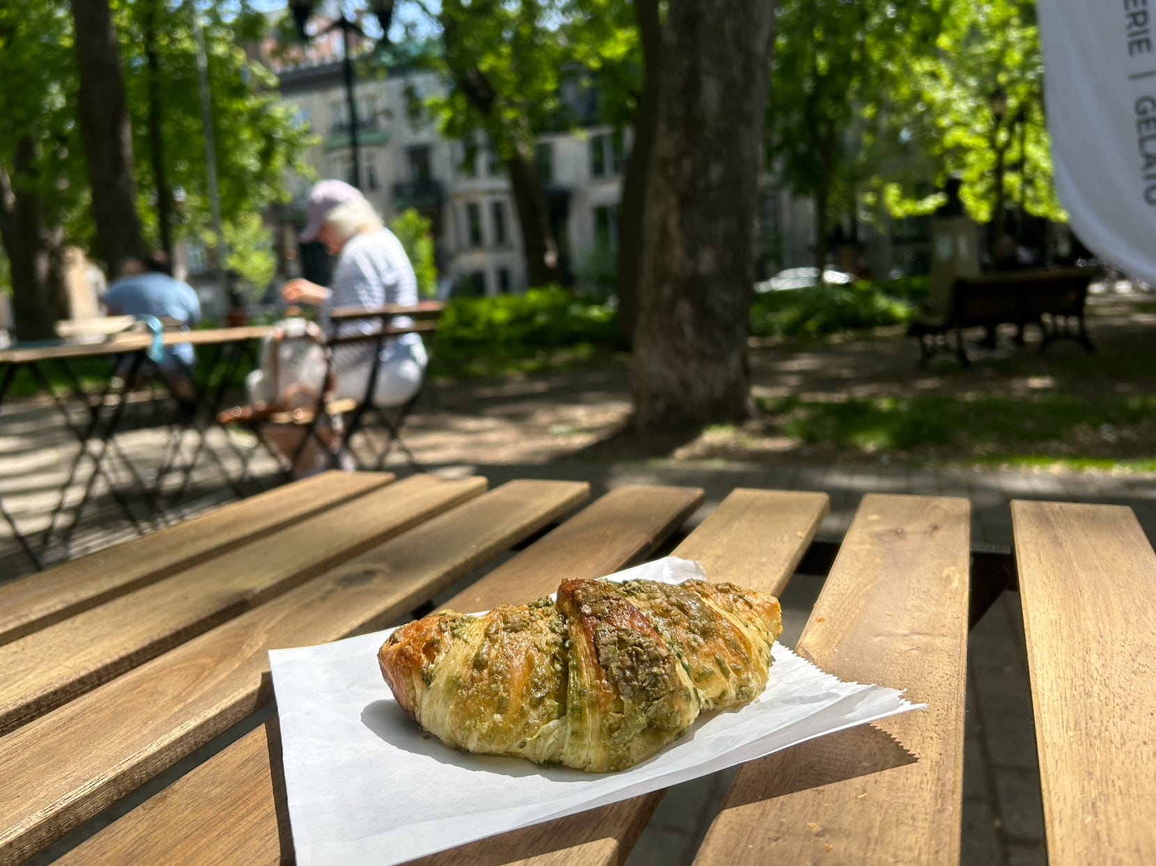 pistachio croissant sitting on a picnic table outside