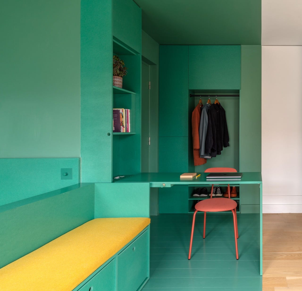 A desk and sofa in a tiny studio in London.