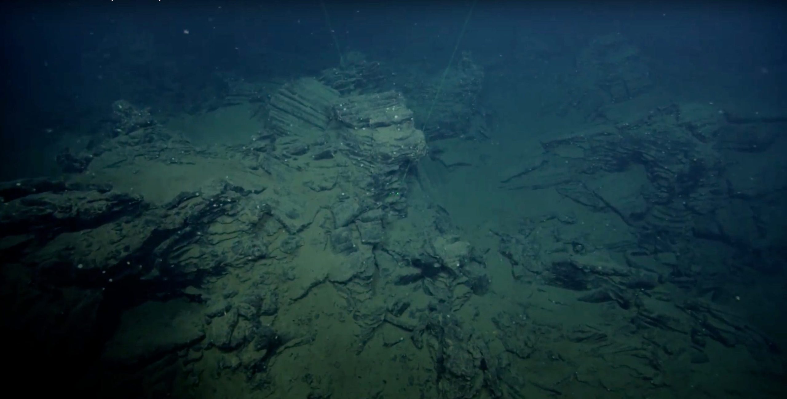 bottom of the ocean sandy rock formation in dark waters