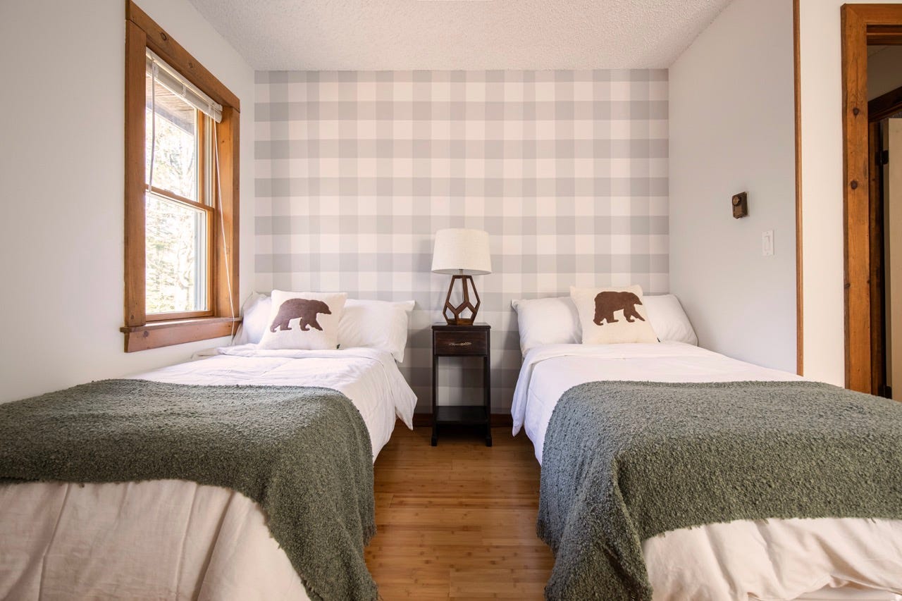 Gingham wallpaper in bedroom with two beds