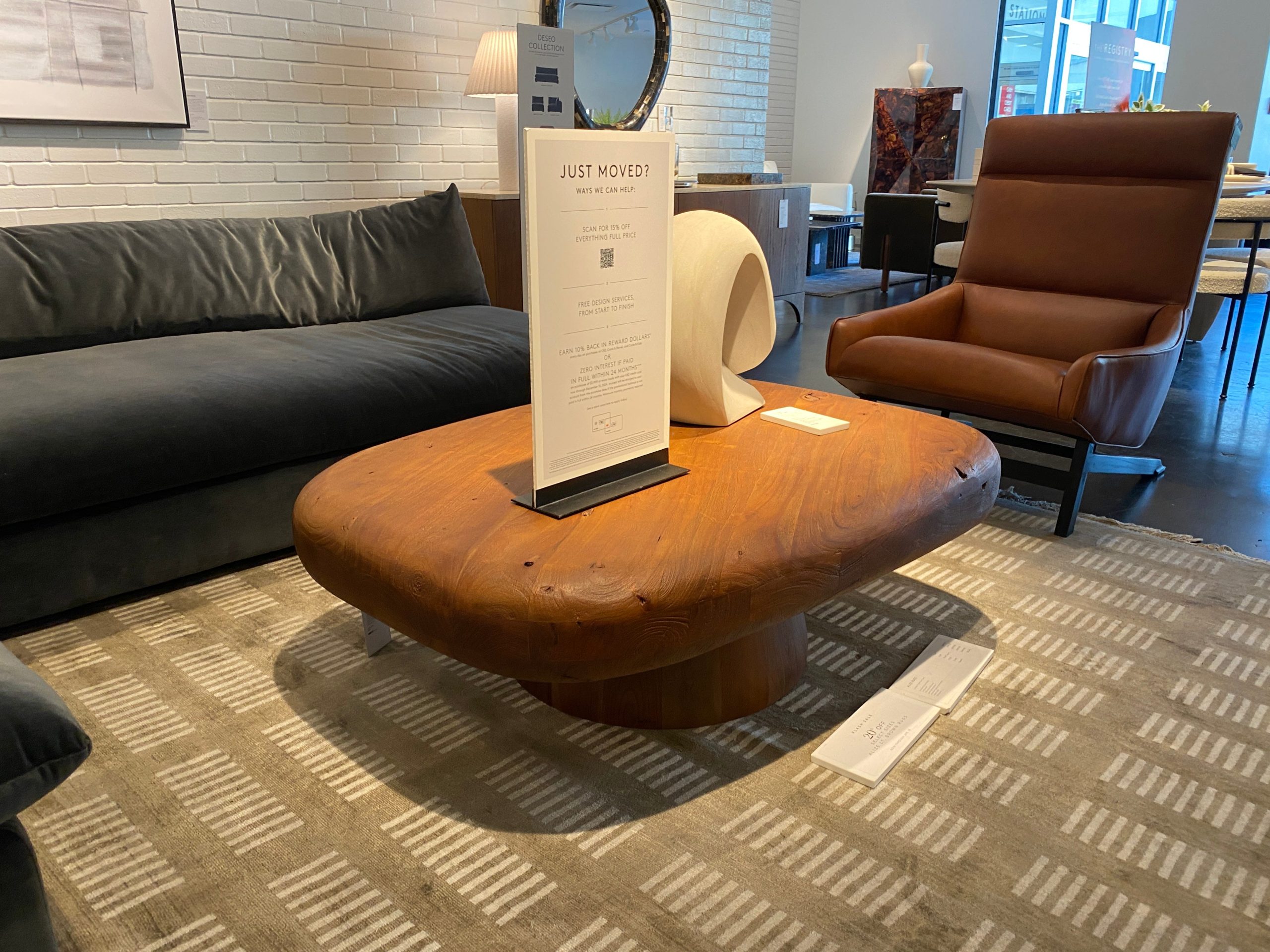 Stone coffee table in brown color on green carpet in CB2