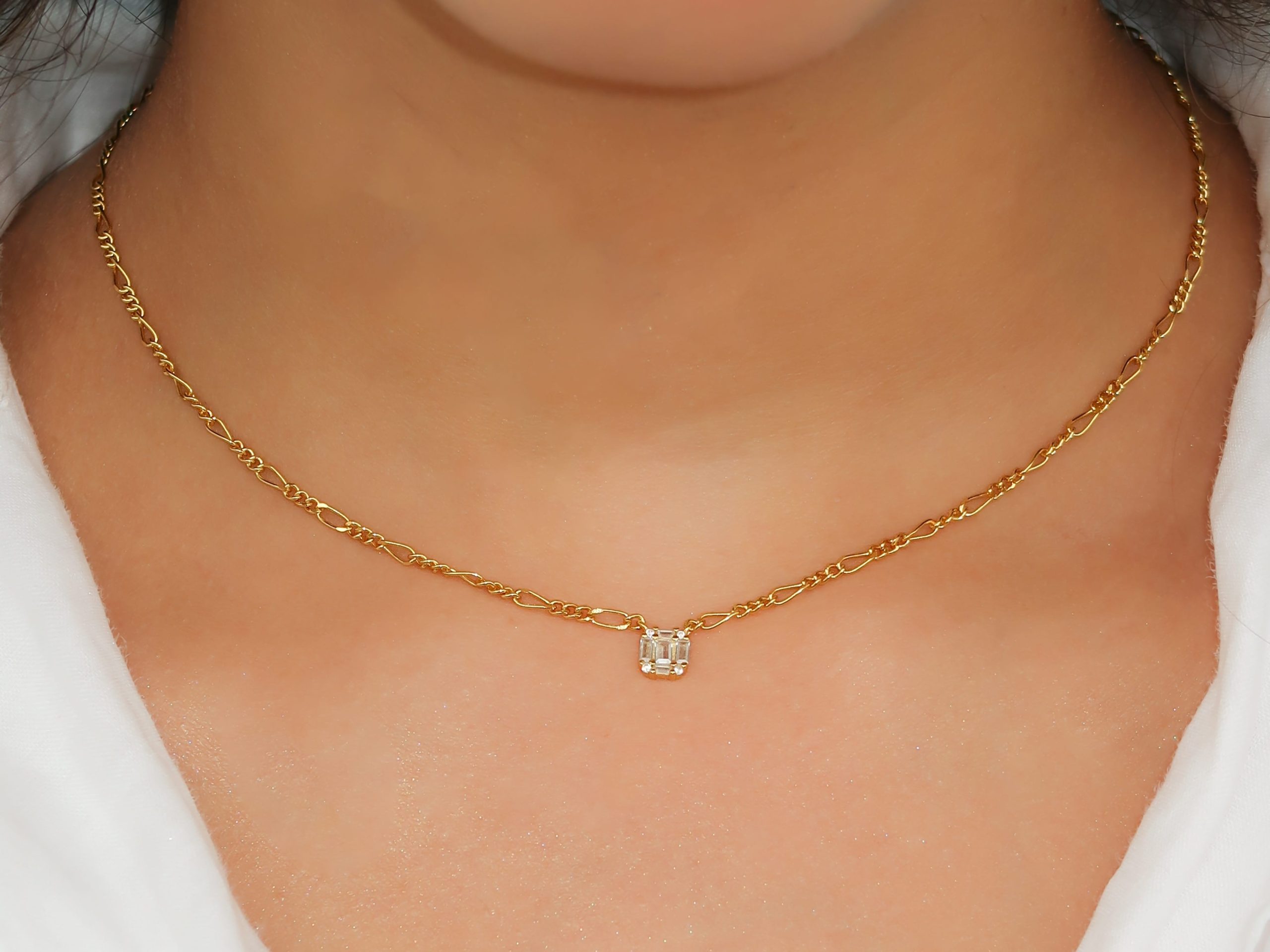 close up shot of a woman wearing a simple gold necklace