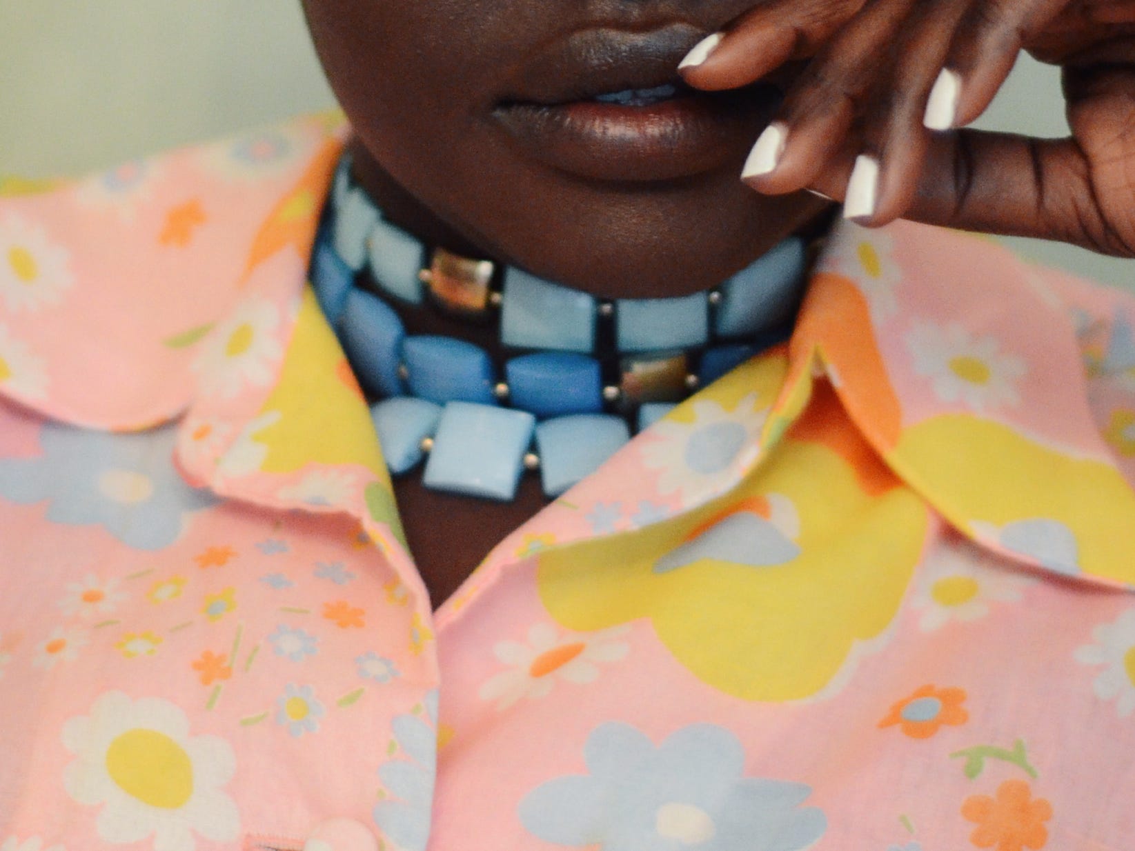 closeup shot of a woman wearing a chunky blue necklace