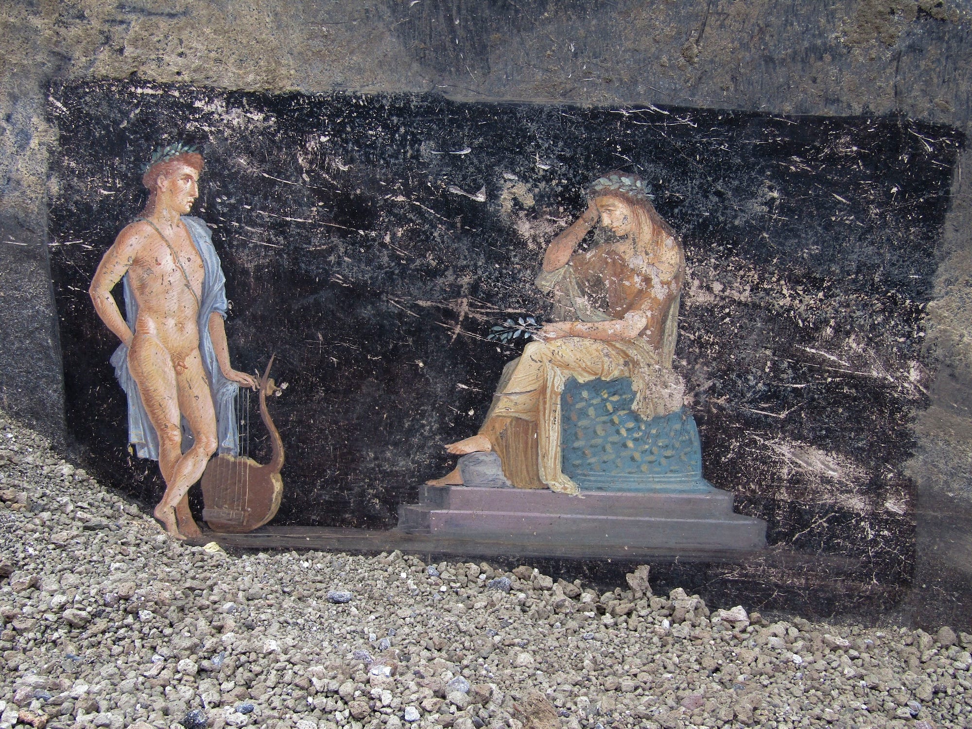 A fresco on a black wall depicting Cassandra, right, a cursed prophetess, and Apollo, God of oracles and knowledge