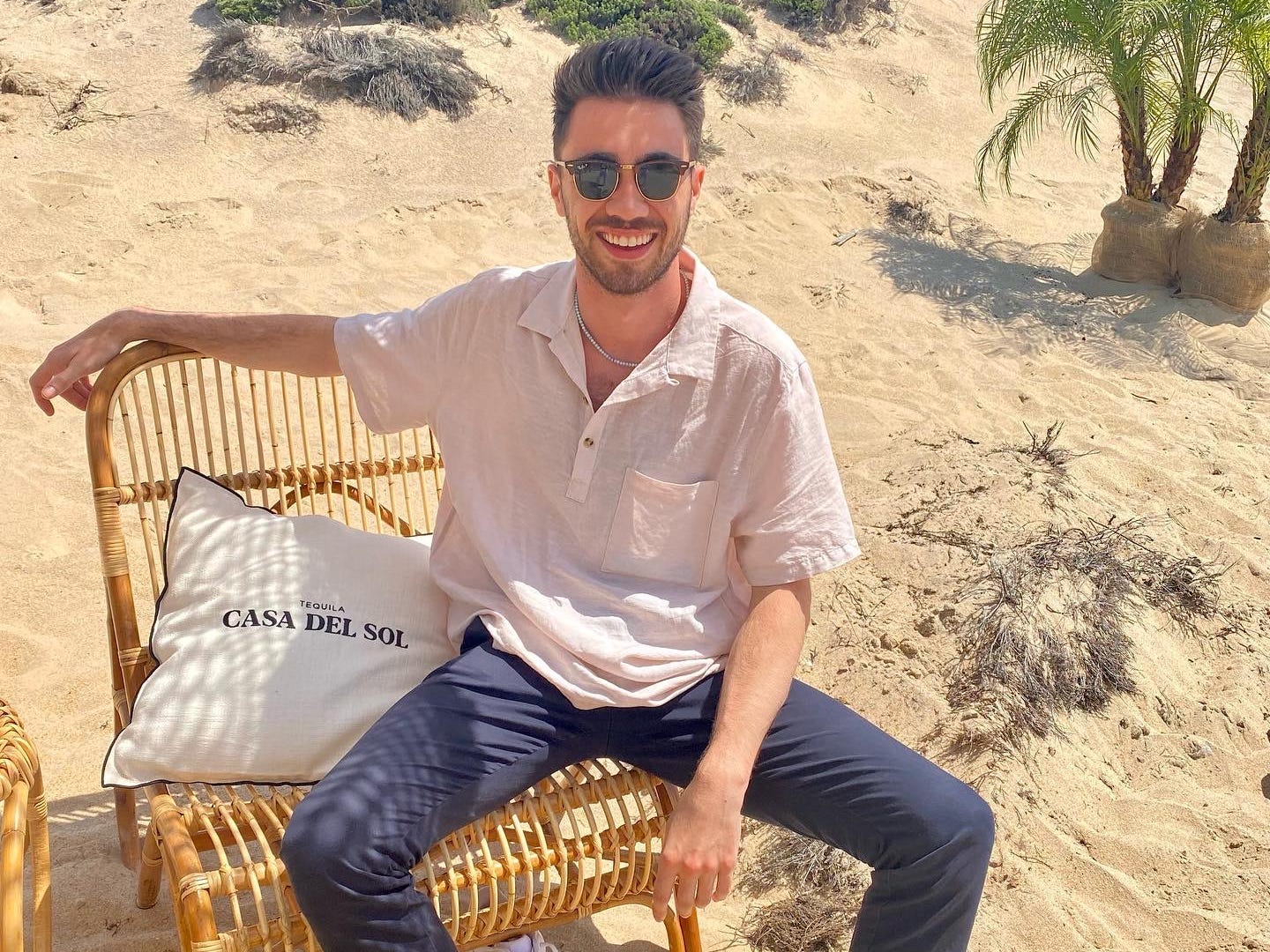 a man sits on a chair on the beach