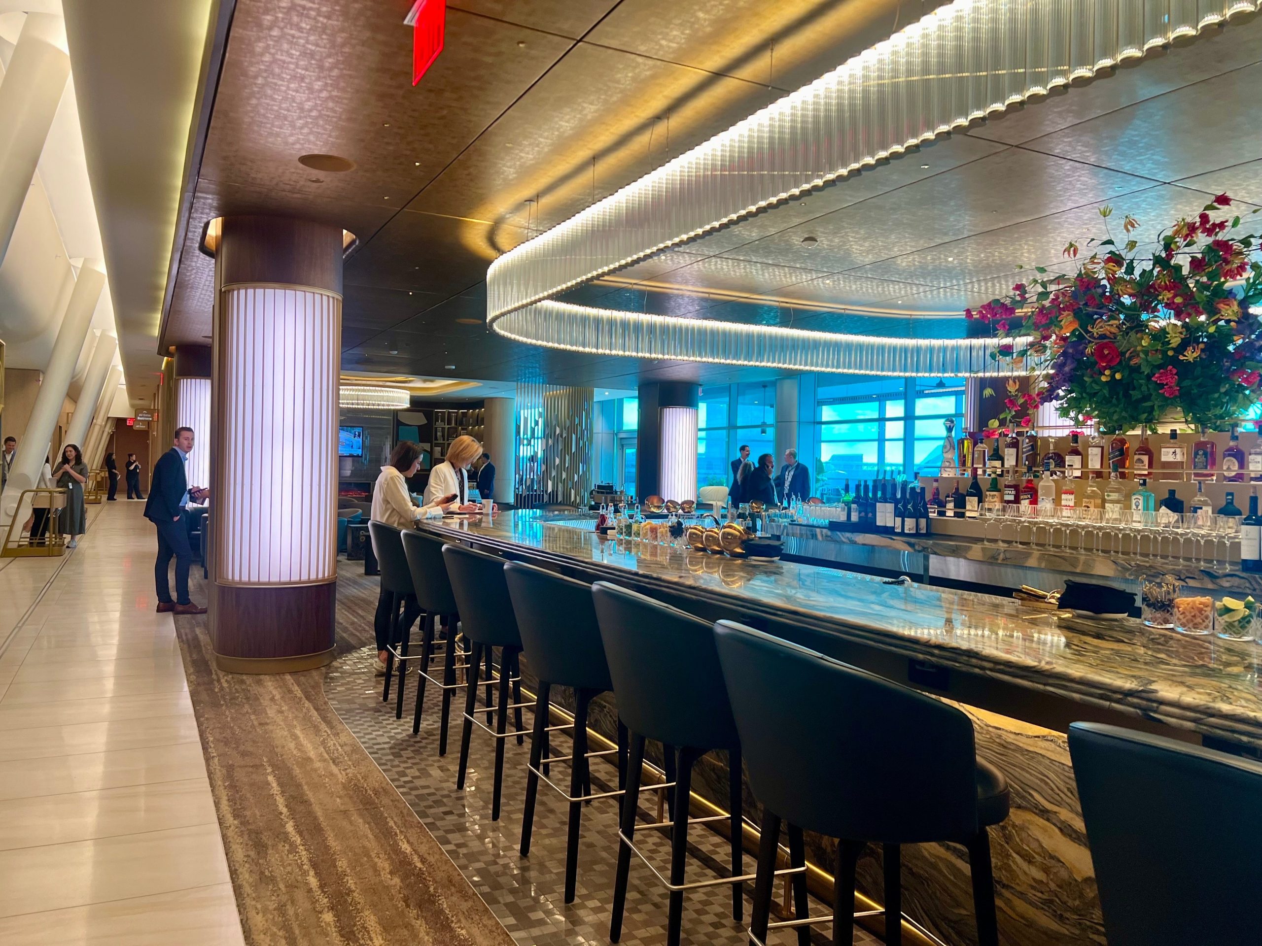 The bar at the Delta One lounge with black high top chairs.