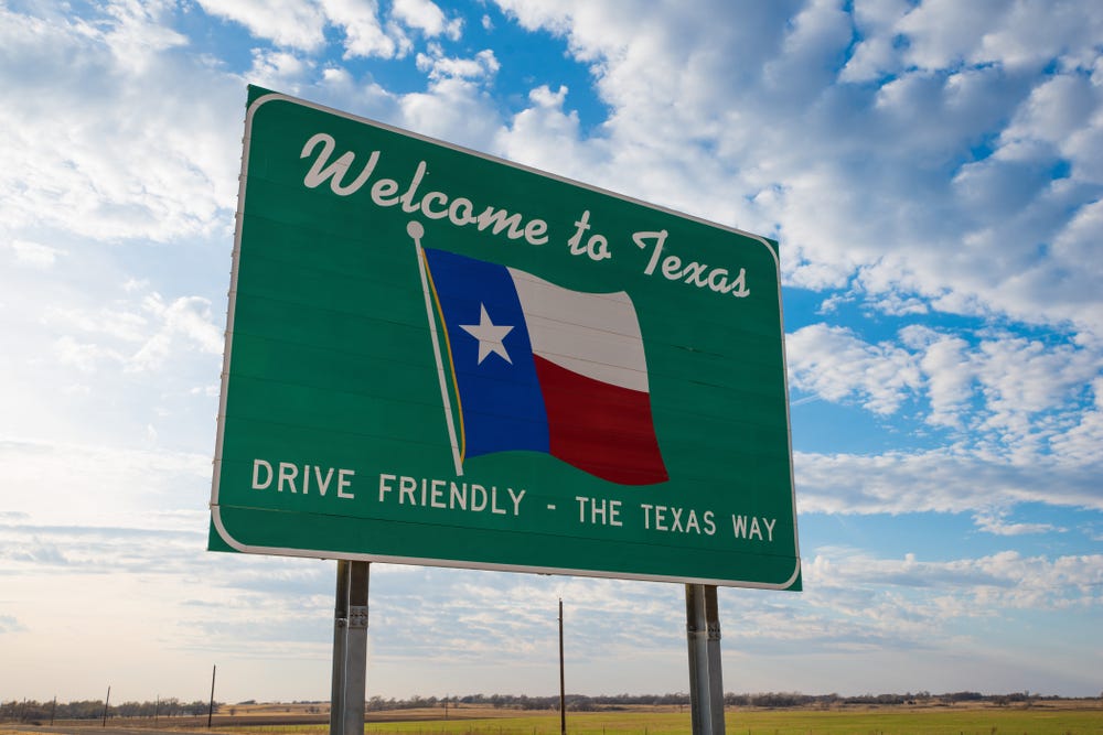 A road sign at the Texas border that reads "Welcome to Texas. Drive friendly - the Texas way."