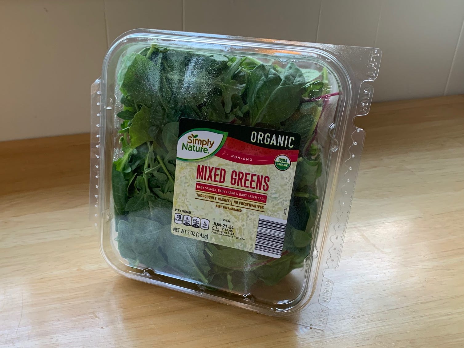 box of mixed salad greens on a kitchen counter