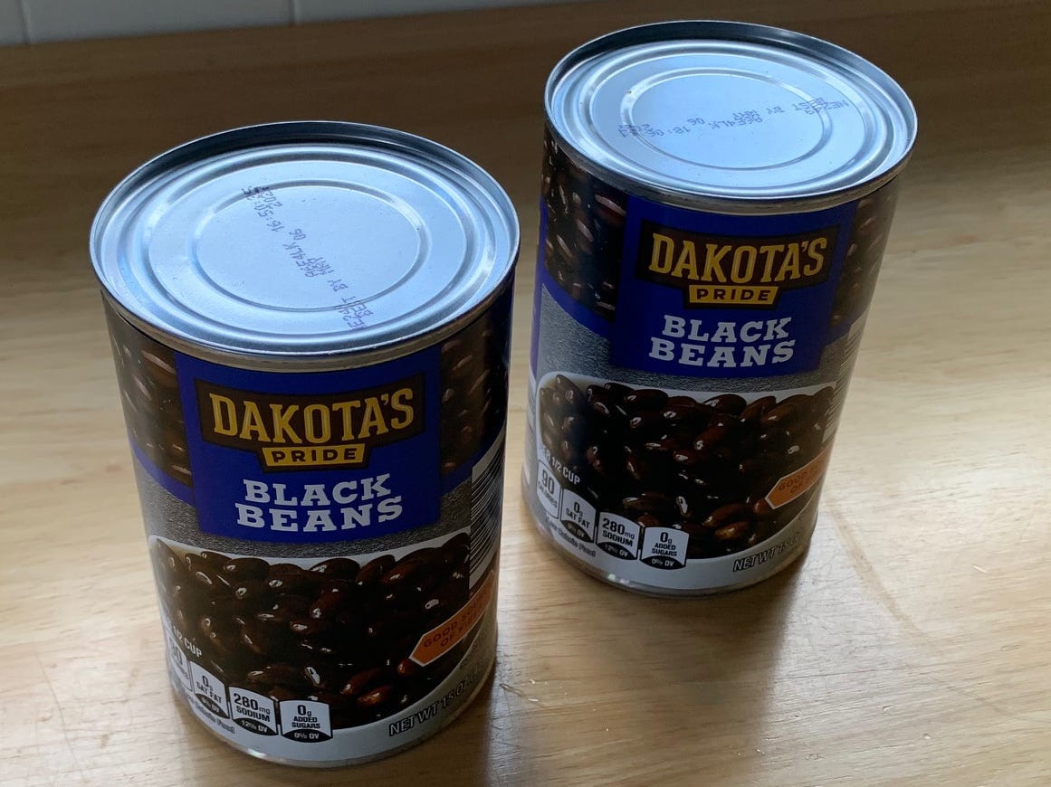 2 cans of black beans on a kitchen counter