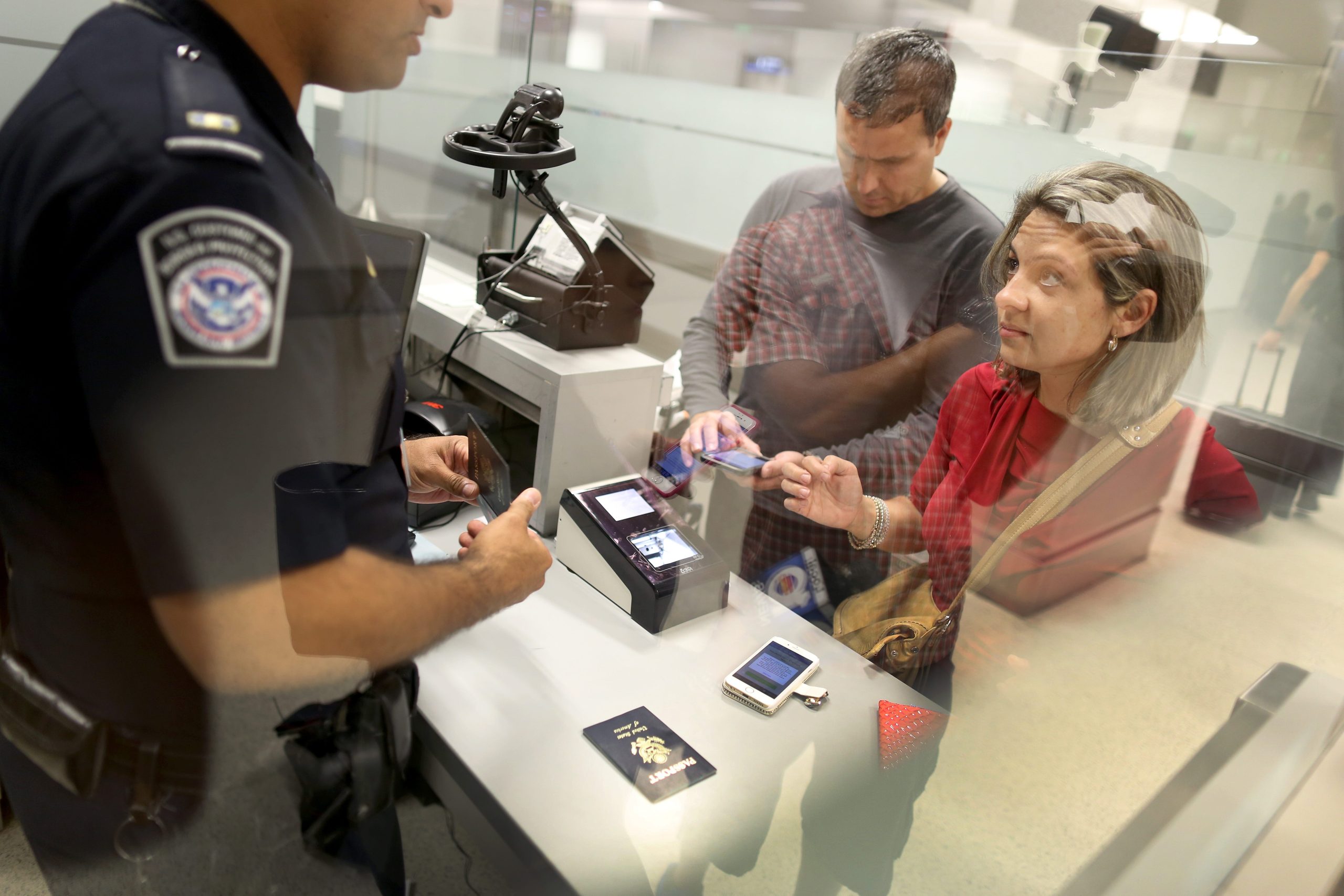 A couple speaks to a CBP officer as they try to use their new mobile app at an entry point