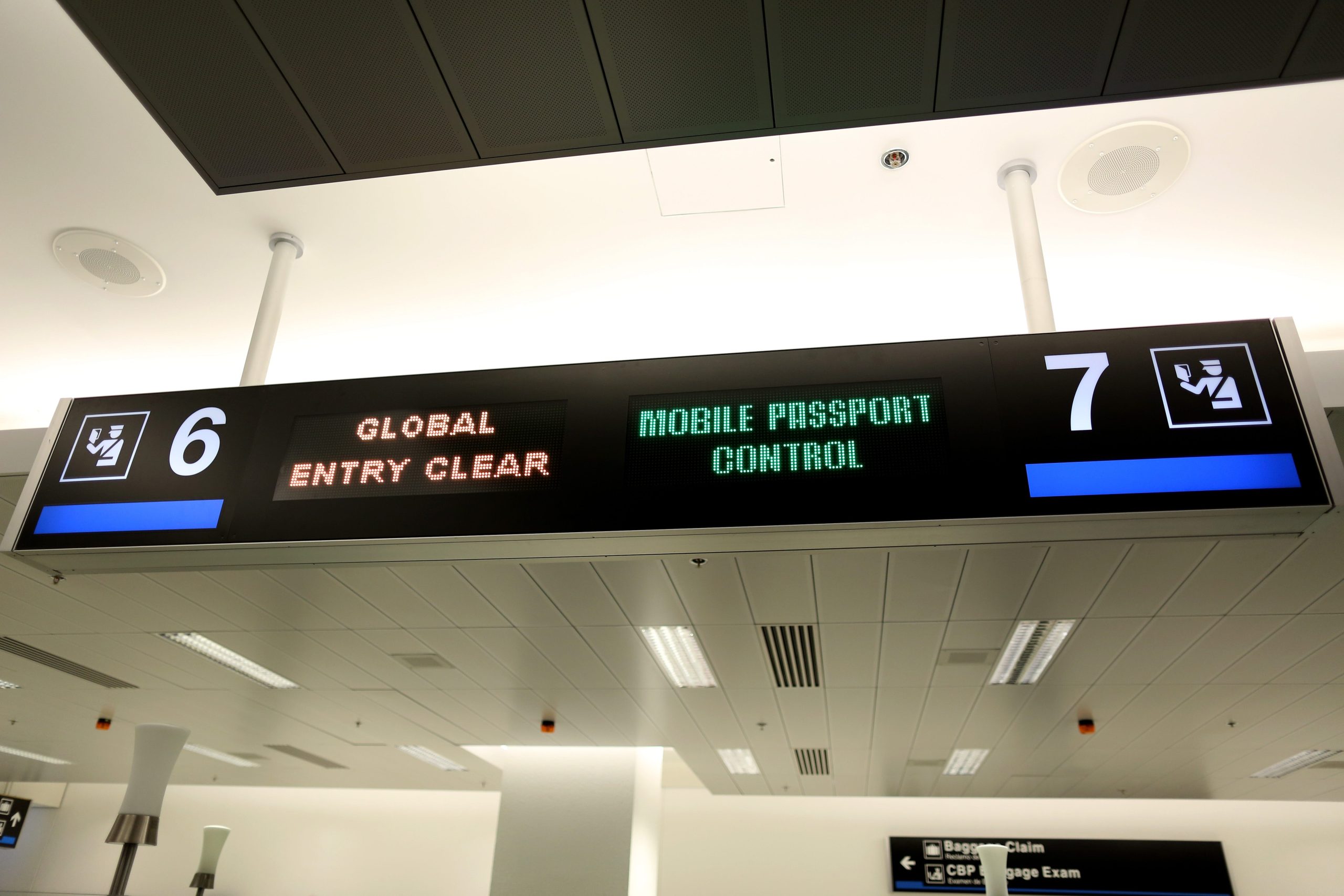 A sign points passengers to the mobile passport control window set up for international travelers arriving at Miami International Airport