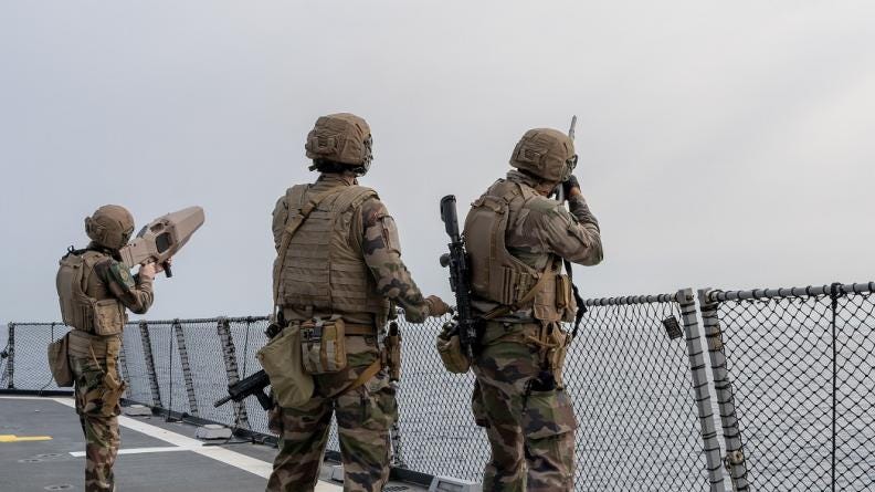 Soldiers fire at an unmanned aerial vehicle from a FREMM-class frigate.