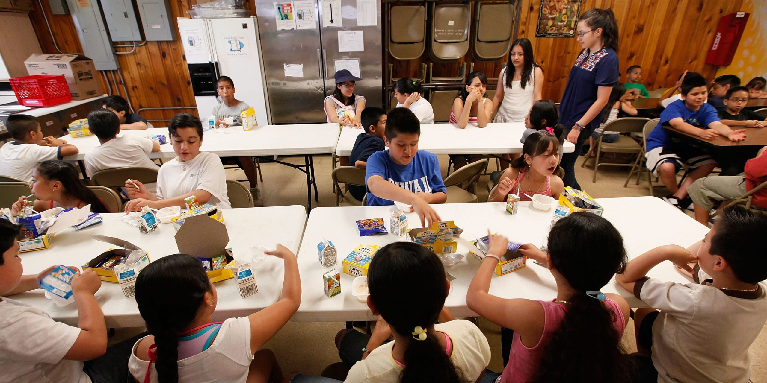 Kids sit at a lunch table eating