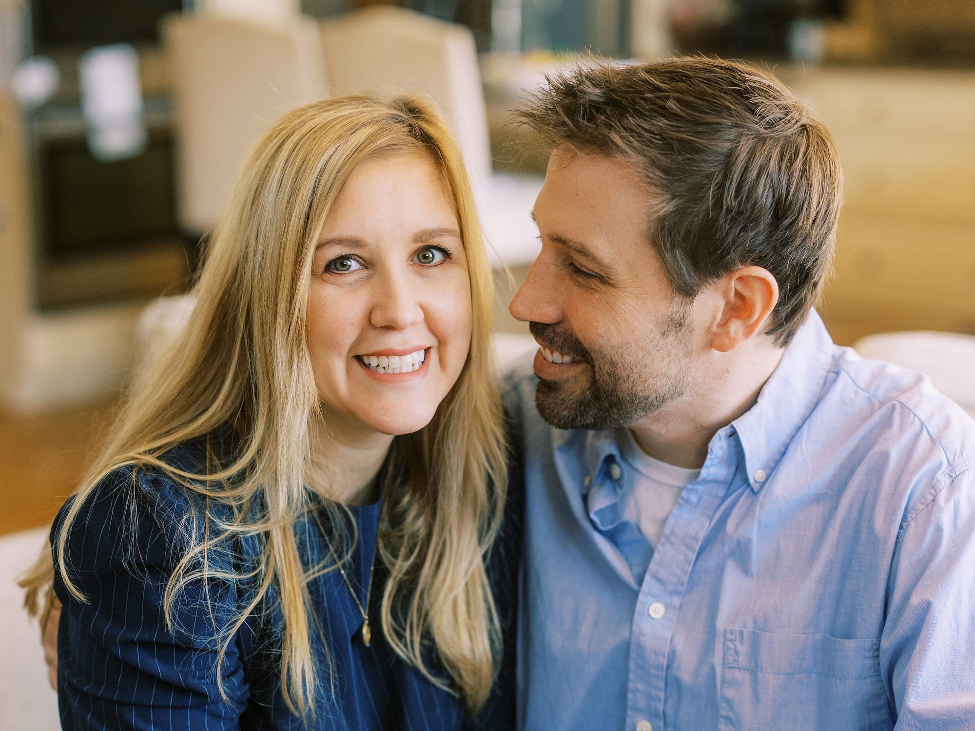 Andrea Mac and her husband sitting and smiling.