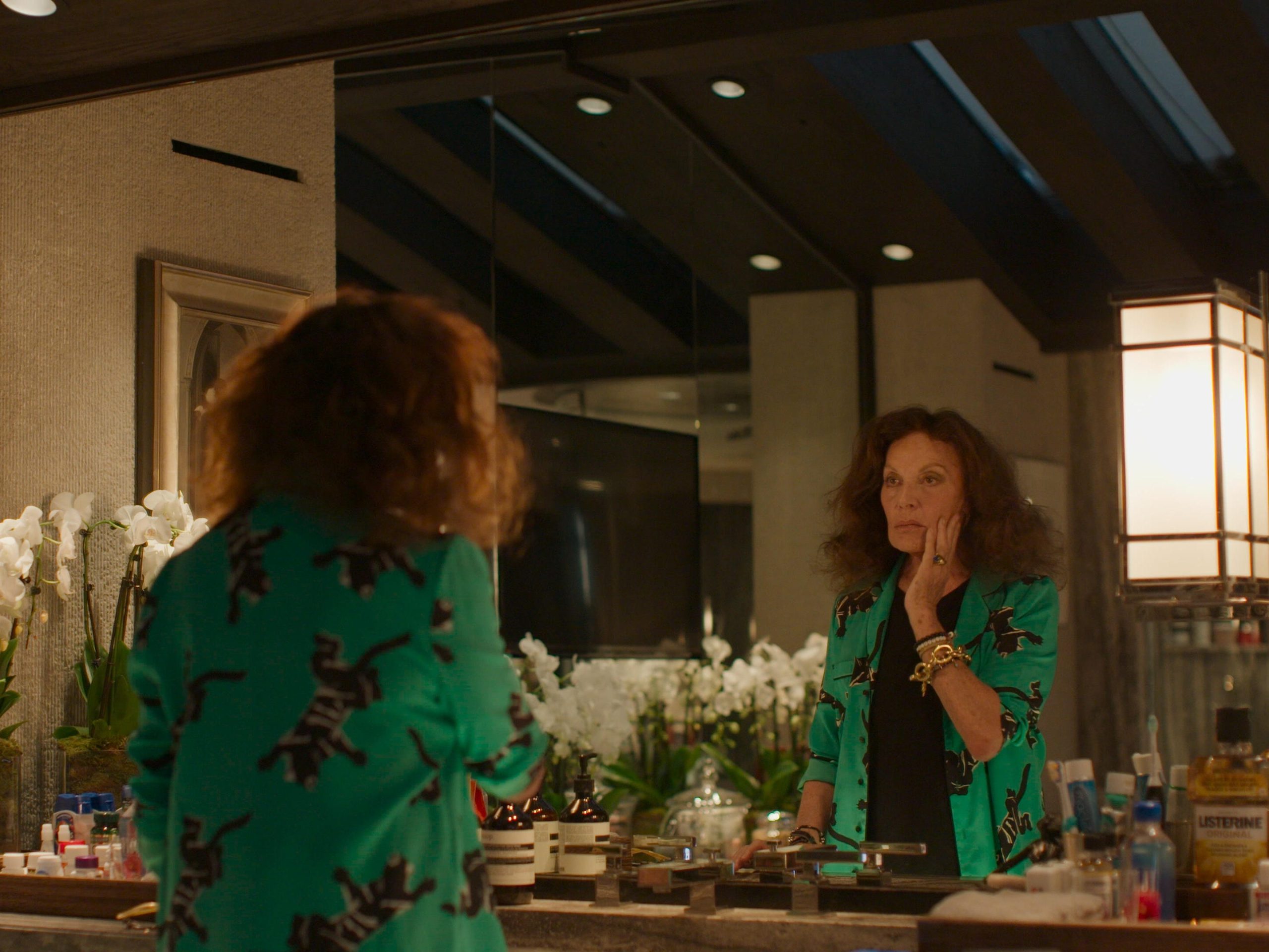 Diane von Furstenberg looks at herself in a mirror