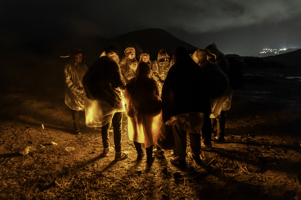 Immigrants from Ecuador warm themselves after crossing the U.S.-Mexico border on March 6, in Campo, Calif. Migrants from Ecuador, China, Georgia and other nations waited for U.S. Border Patrol agents to collect them to process asylum claims.